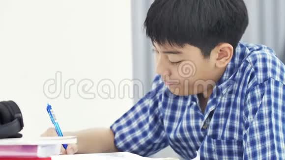 亚洲可爱的男孩做你的家庭作业微笑的脸在家4K多莉射击视频的预览图
