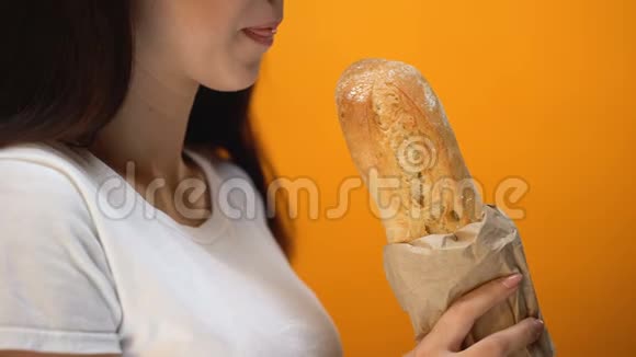 饥饿的女孩咬新鲜出炉的面包面包中的纤维和面筋医疗保健视频的预览图