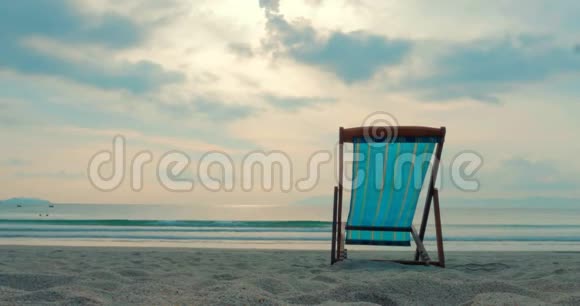 在沙滩上在背景海和美丽的日落或日出的热带海滩上近距离欣赏朗格视频的预览图