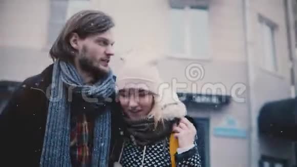 快乐轻松的年轻浪漫夫妇穿着温暖的衣服走得很近在一个非常寒冷的雪冬天交谈和微笑视频的预览图