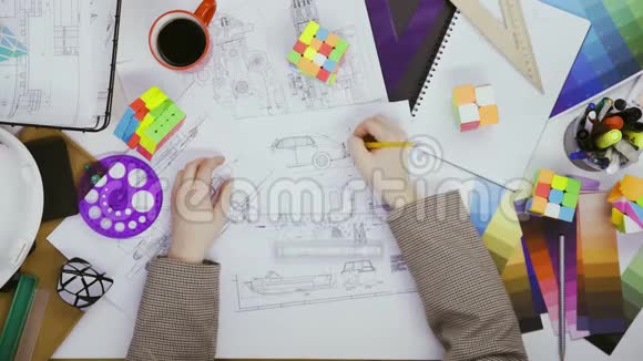顶视图工程师正在绘制汽车设计草图并玩2x2魔方视频的预览图