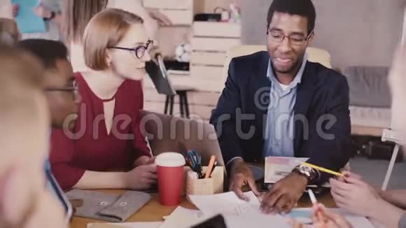 非裔美国人成功的男性商业教练领导多民族办公室团队会议显示在桌子上的图表上视频的预览图