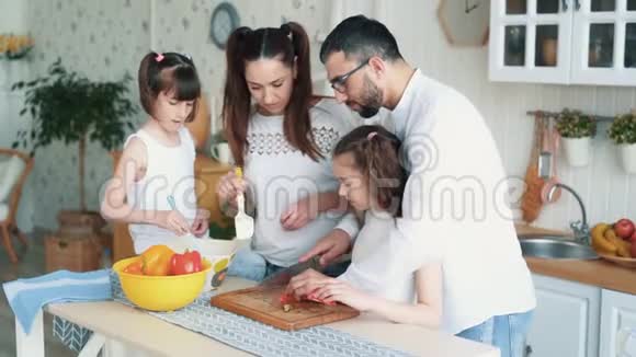 幸福的家庭在厨房准备食物切菜慢动作视频的预览图