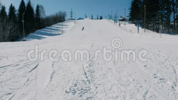 穿着黄色夹克衫的人从雪下滑到滑雪板上在城市公园的天空电梯里视频的预览图