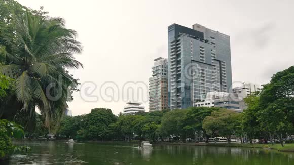 绿色的城市公园和大池塘在城市摩天大楼的背景下白天美丽的城市景观视频的预览图