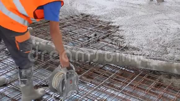 工人们正在施工现场的大钢筋地板上摊铺混凝土视频的预览图