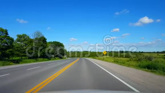 在晴朗的夏日沿着森林行驶乡村道路司机观点POV美丽的卢什绿叶视频的预览图