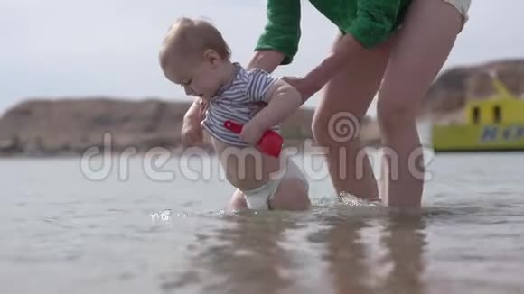 小孩子和母亲一起在水里慢动作地保护他视频的预览图