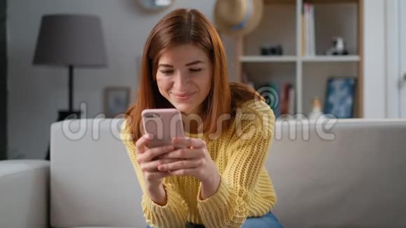 年轻成功的女人在家客厅家里使用智能手机应用程序兴奋的女孩收到好消息兴奋地高兴视频的预览图