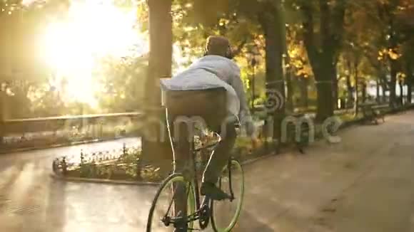 难得看到年轻人在公园里骑自行车用黑色耳机听音乐一个人骑着自行车视频的预览图