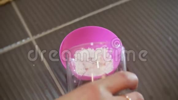 4K美观女人手在粉红色的杯子里搅拌海藻酸钠面膜视频的预览图