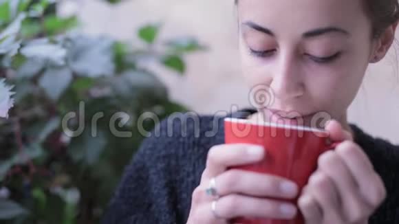 高清特写镜头中的女人拿着一杯咖啡女人在户外喝咖啡享受咖啡的味道视频的预览图