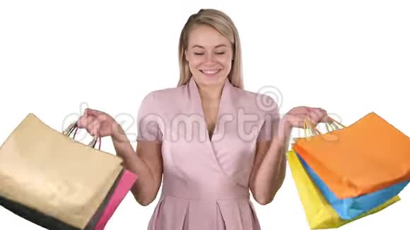 兴奋的漂亮年轻女士站着看相机在白色背景上展示购物袋视频的预览图