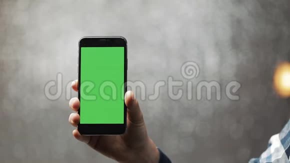 银幕背景人手握绿屏智能手机特写视频的预览图