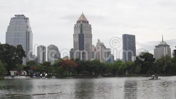 市区湖滨的高楼大厦平静的景象池塘水面上荡起涟漪视频的预览图