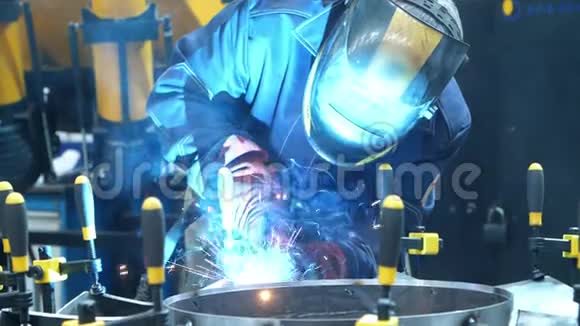 戴面具的工人用手工夹子固定金属坯料的焊接视频的预览图
