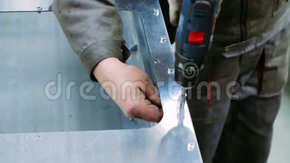 工人用带喷嘴的螺丝刀拧紧金属块螺栓视频的预览图