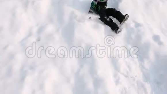 男孩滚下雪山向前跑侧视视频的预览图