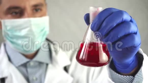 男性科学家将erlenmeyer瓶与化学品混合注意管子视频的预览图