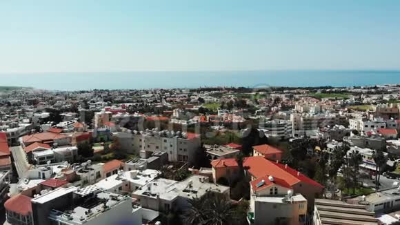 夏季阳光明媚的一天用屋顶和建筑物拍摄帕福斯城的空中照片以海为背景对塞浦路斯城市进行演练视频的预览图