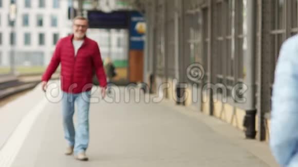 有着白胡子的成熟男人在车站遇见他心爱的人在车站迎接男女这是一个期待已久的视频的预览图