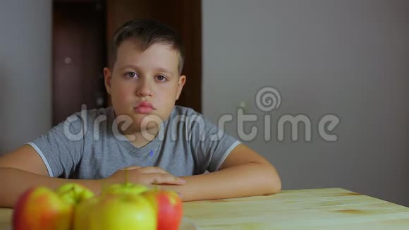 悲伤的男孩坐在桌子旁他不想做作业小学生懒惰视频的预览图