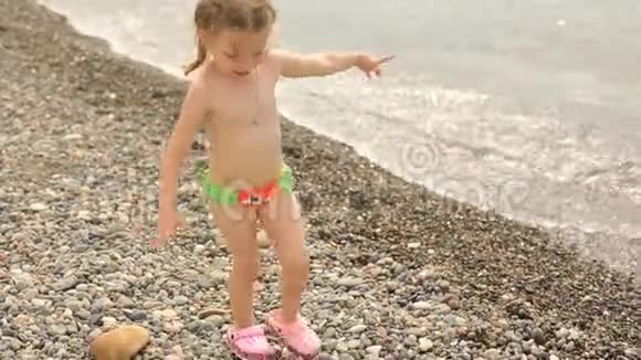一个小女孩把石头扔进海里暑假在水边视频的预览图
