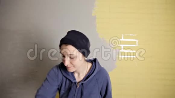 家庭修理女孩用一个大金属抹子把石膏铺在墙上使墙上的石膏填料对齐视频的预览图