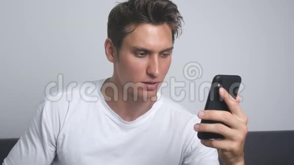 迷人的微笑男人使用智能手机发送社交媒体信息在室内喝咖啡视频的预览图