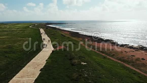 鸟瞰海边海岸线行人漫步海滩帕福斯塞浦路斯长廊海上和海滨的无人视野视频的预览图
