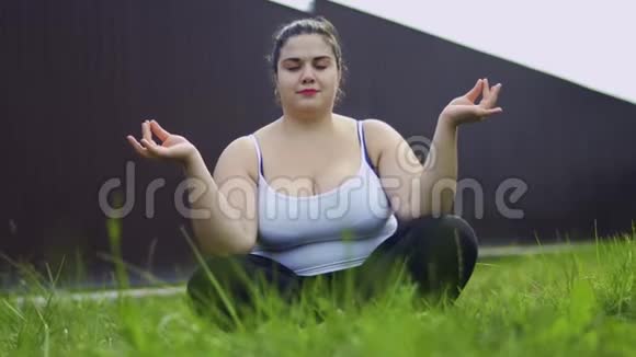 胖女孩坐在草地上沉思视频的预览图