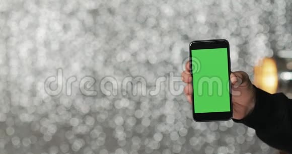 银幕背景人手握绿屏智能手机特写视频的预览图