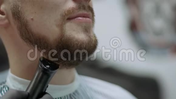 理发店用剃须刀刮胡子的男士特写视频的预览图