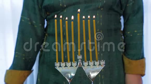 犹太妇女在光明节上用漂亮的烛台点燃蜡烛视频的预览图