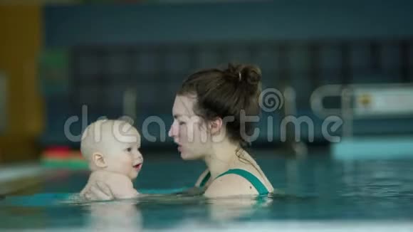 加速录像年轻的母亲教她那岁的婴儿在游泳池里潜水这孩子很高兴发展视频的预览图