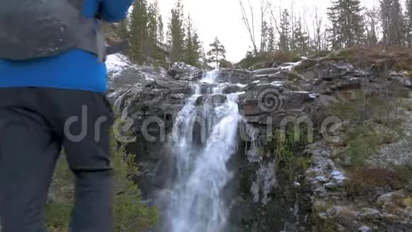 登山者独自走在一条山路上走近一条美丽的瀑布活跃有趣的生活视频的预览图