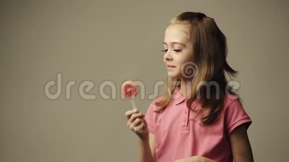 女孩咬着棒棒糖笑着视频的预览图