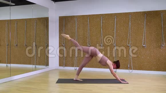 年轻女子在慢动作瑜伽馆练习瑜伽视频的预览图