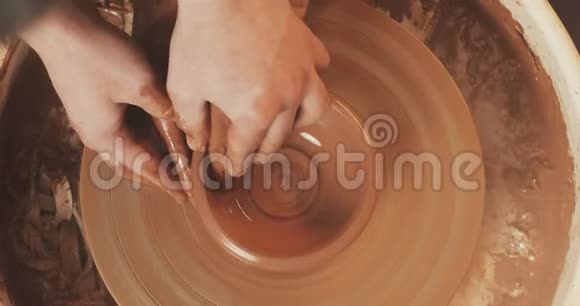 一个男人和一个女人的手在陶工的泥上车轮塑造了一个花瓶陶工在一个陶工作坊里用粘土干活视频的预览图