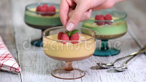 欧式甜点民族美食焦糖奶油慕斯与覆盆子和薄荷一起加入玻璃杯中视频的预览图