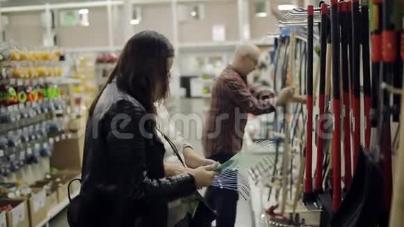 一对老年夫妇和成年女儿在五金超市选择耙视频的预览图