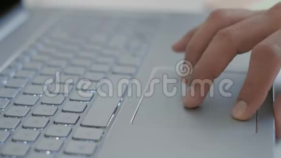 Macro印度学生手在笔记本电脑上的触摸板上进行搜索视频的预览图