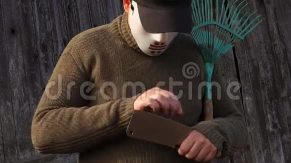 戴万圣节面具的人检查刀片的锋利度视频的预览图