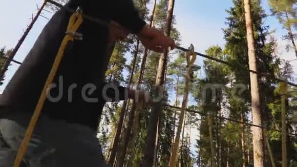 镜头跟随着一个人走在树木之间的电缆上视频的预览图