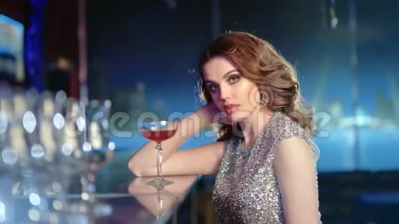 派对期间时尚女性坐在酒吧喝鸡尾酒的中镜头肖像视频的预览图