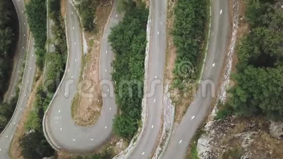 蛇形窄路的高空俯视图一条充满曲折的道路蜿蜒曲折地蜿蜒在一座山上视频的预览图