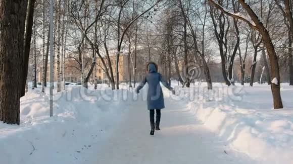 年轻女子在公园的小巷里跑步享受冬天背面和正面视图视频的预览图
