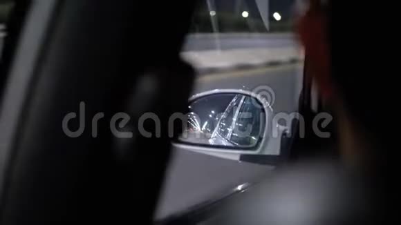 夜间在路上行驶的汽车侧镜的反射视频的预览图