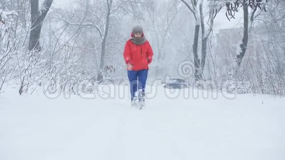穿着滑雪服的女人在暴风雪中拍照旅行者去路边的雪视频的预览图