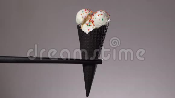 香草冰淇淋融化在一个黑色的蛋饼时间流逝视频的预览图